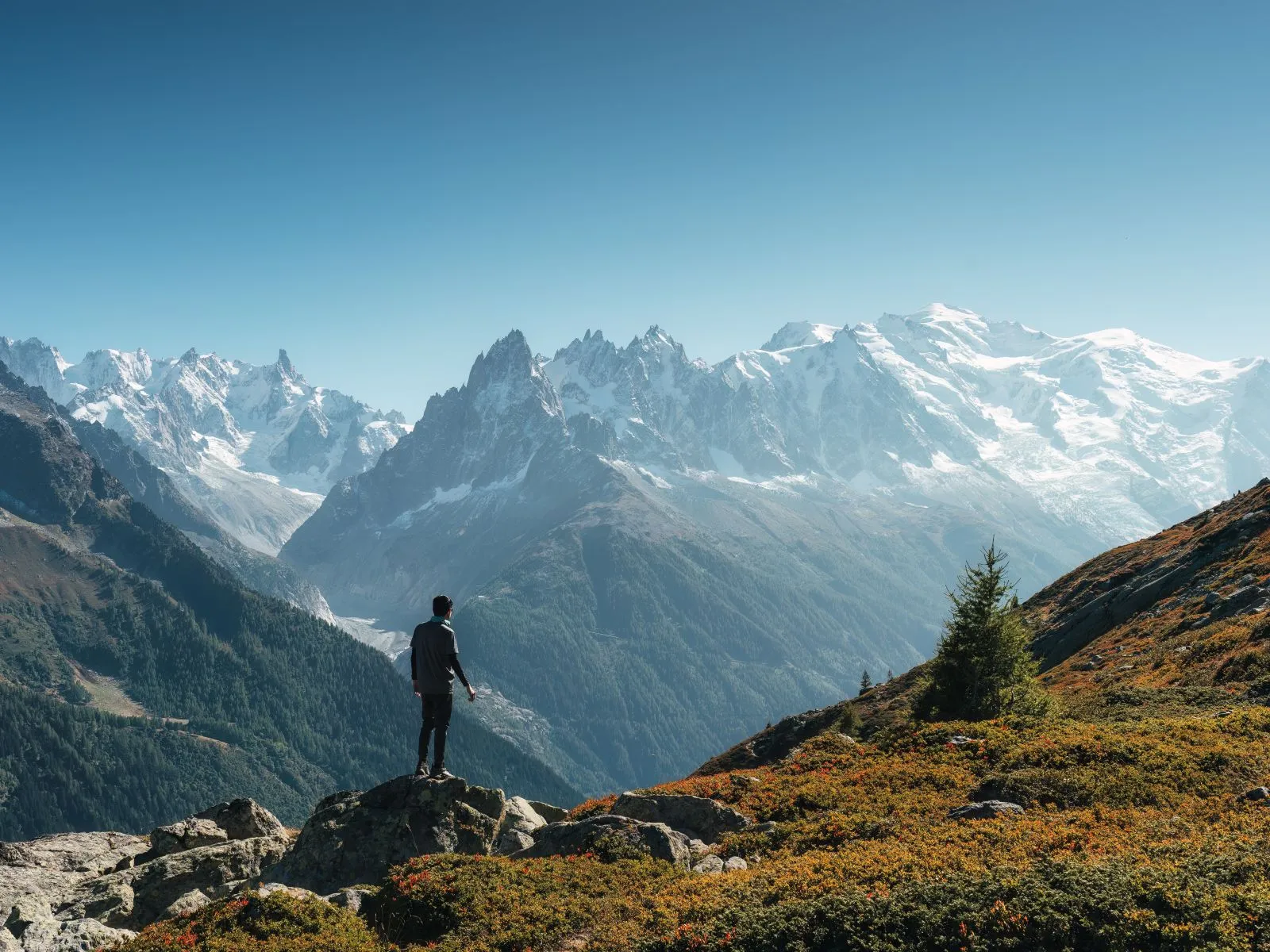 male traveler standing with enjoying the mont blanc massif during trail among the french alps at chamonix france