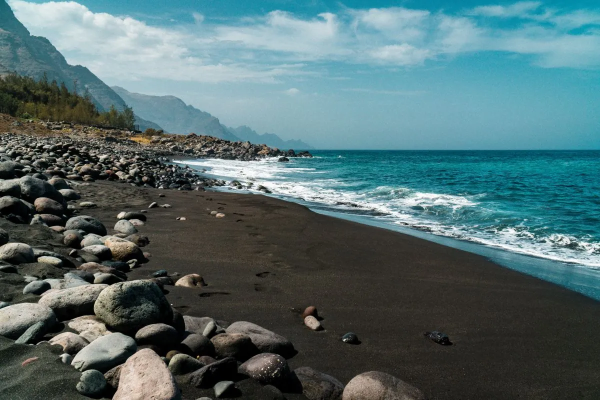 black beach playa de guayedra with volcanic boulders in las palmas on gran canaria